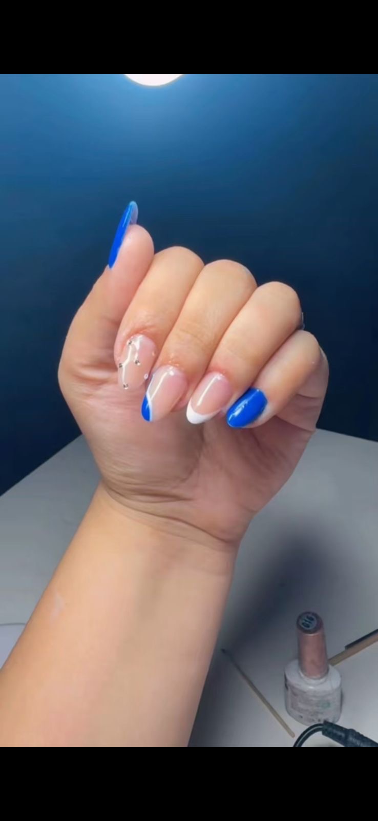 Unhas com esmaltação em azul e branco, trabalho do studio